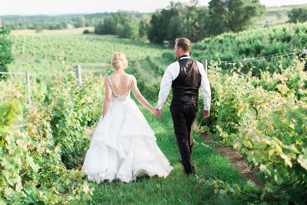 Couple walking through vineyard rows